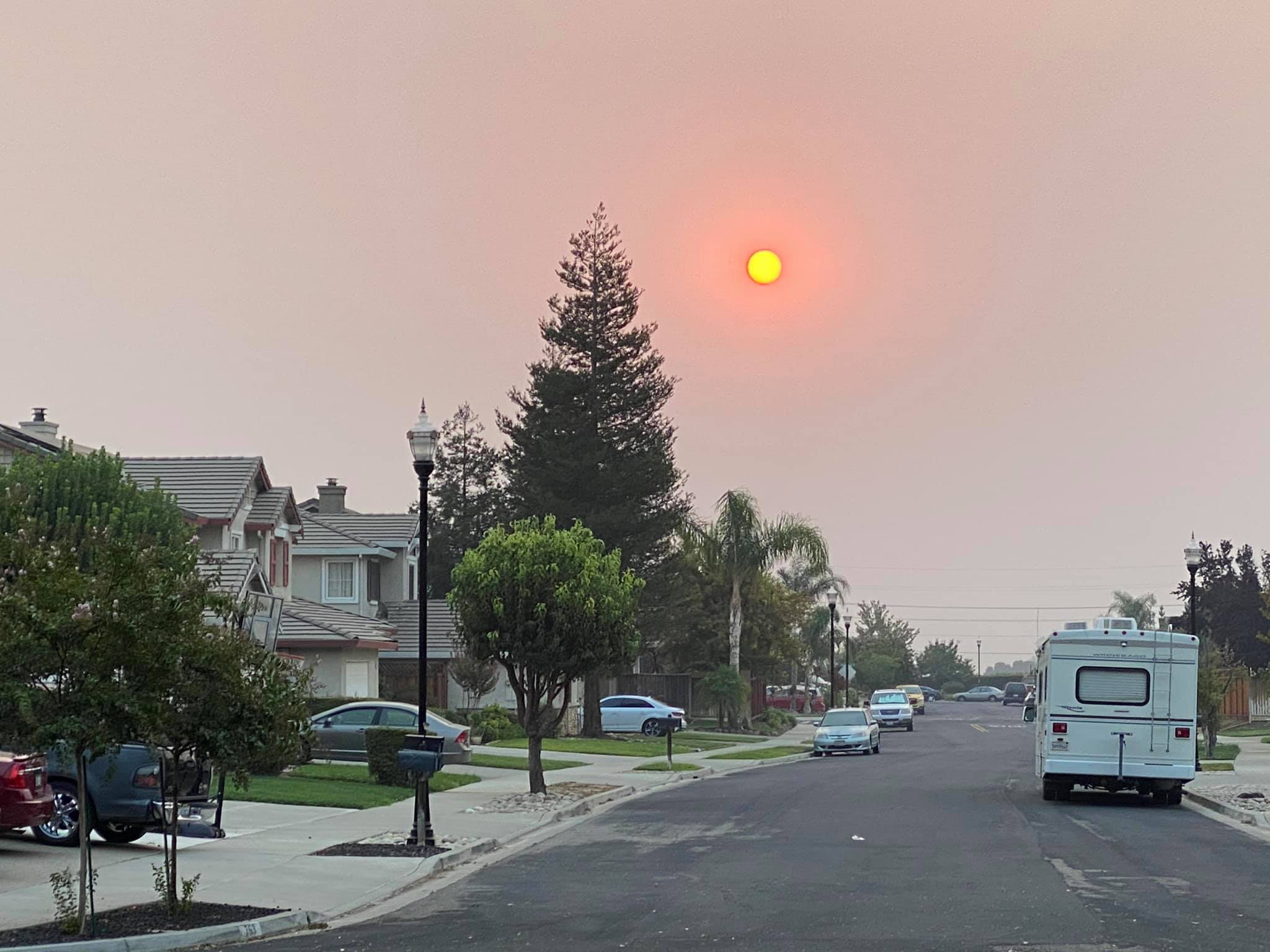 The sun through wildfire smoke over a Bay Area street