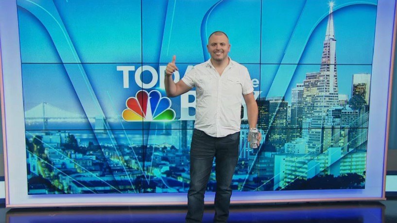Andrew Gillfillan standing in the studio before the Today in the Bay video wall